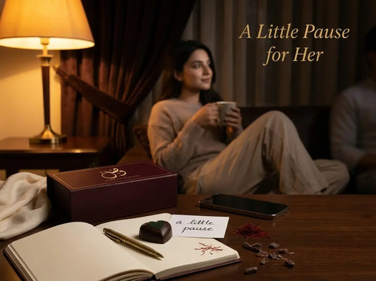 Premium dark chocolate and a self-care journal on a warm Pakistani side table with a softly blurred woman near a lamp