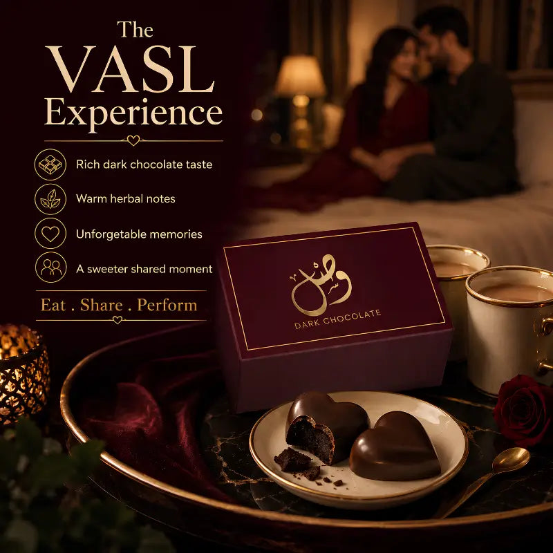 A dark chocolate gift box in deep burgundy with gold lettering sits on a tray beside heart-shaped chocolates on a plate, with cups and a romantic couple blurred in the background. Text on the left reads 'The VASL Experience' with chocolate flavor benefits.