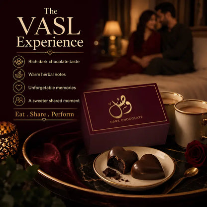A dark chocolate gift box in deep burgundy with gold lettering sits on a tray beside heart-shaped chocolates on a plate, with cups and a romantic couple blurred in the background. Text on the left reads 'The VASL Experience' with chocolate flavor benefits.